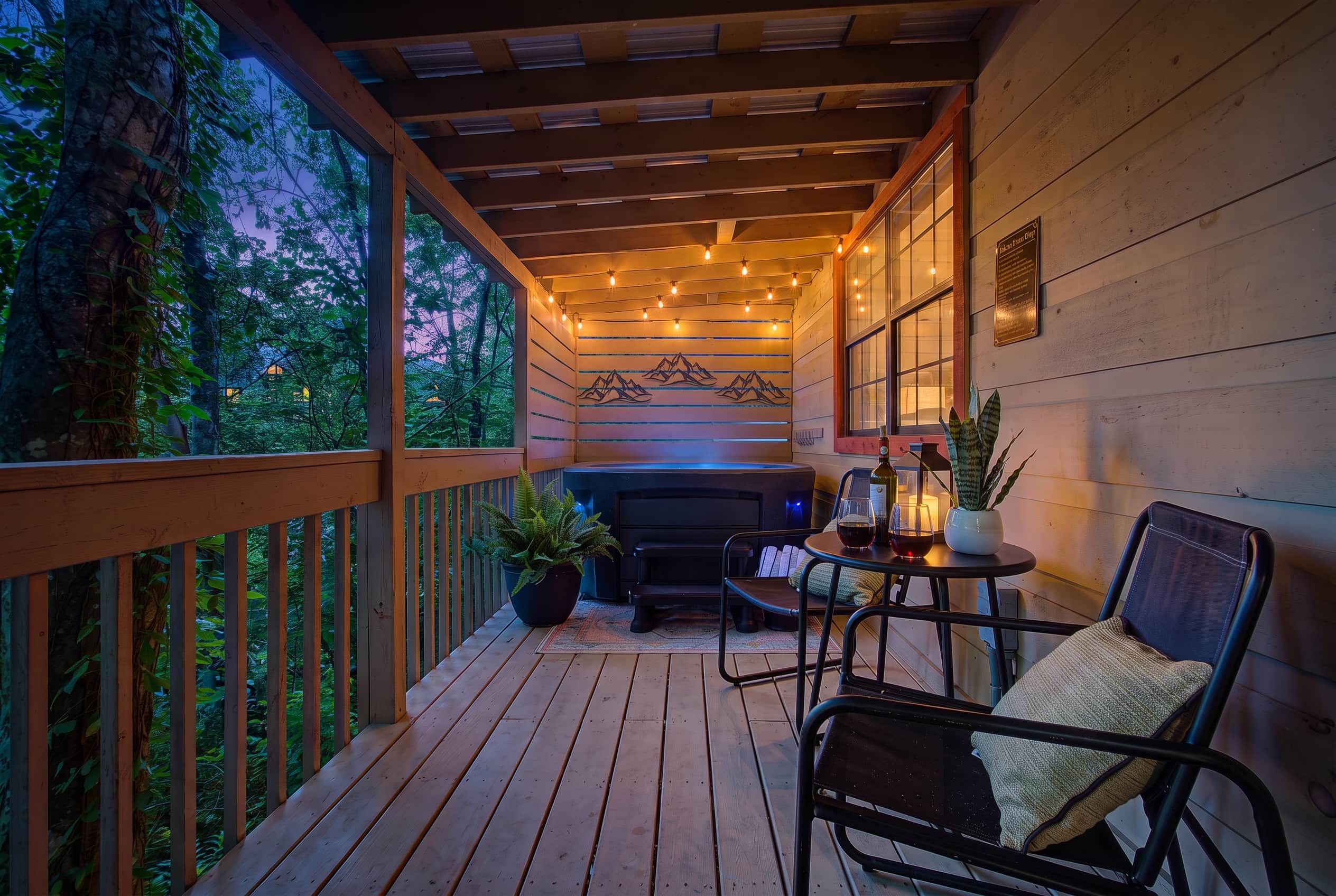 A wooden deck with a barbecue grill, outdoor seating, and a view of the surrounding trees.