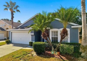 A residential house with a garage, palm trees, and a well-maintained lawn. - 4BR/King Bed/12 Guest/Disney/Game Rm/Snow Bird Heated Pool/Full Equipped Kitchen (Davenport)