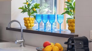 A kitchen with a sink, a bowl of fruit, and a coffee maker. - Bright 2-Bedroom Apartment – Close to La Croisette & City Centre (Cannes)