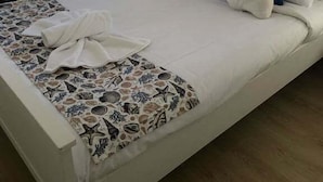 A neatly made bed with a patterned bedspread, pillows, and a towel. - Pet Friendly Coastal Stay Near The Beach. (Bundaberg)