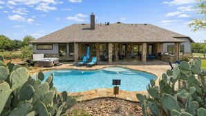 A house with a pool, outdoor seating, and cacti. - Private 16-Acre Retreat, Pool, Hot Tub & Hill Country Views - Sleeps 16 (Hays County)