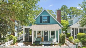 A two-story house with a front porch, a chimney, and a white picket fence. - 🏖️ Private Beach Access | Fire Pit | Golf Cart | Bikes | Dog Park | Putting Park (Watersound)