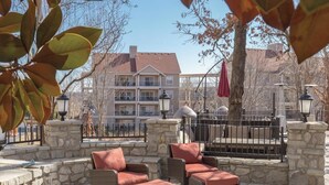 Eine Terrasse im Freien mit Korbmöbeln und Steinwänden.