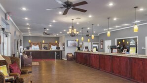 Eine geräumige Lobby mit Empfangstresen, Sitzbereich und Deckenventilator.