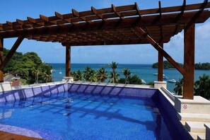 A pool with a wooden pergola, a clear view of the ocean, and a tropical landscape. - Hacienda Samana Bay (Samaná)