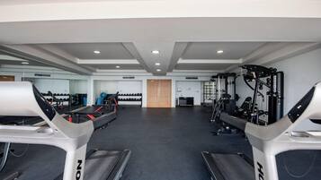 Ein Fitnessstudio mit Laufbändern, Krafttrainingsgeräten und Übungsbällen.