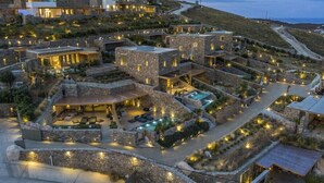 A hillside resort with stone buildings, outdoor seating, and a swimming pool. - Nasta Intentional Living Mykonos (Mykonos)