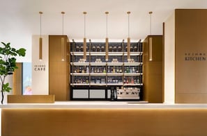 Ein modernes Interieur mit einer Rezeption, hängenden Pendelleuchten und Regalen voller verschiedener Gegenstände.
