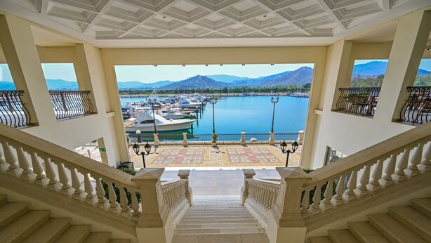 Una imponente escalera conduce a una terraza con vista al puerto deportivo.