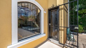 Entrada de un edificio con puerta de cristal y reja metálica.