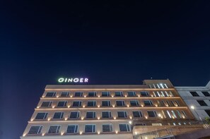 A multi-story building with the name 'GINGER' illuminated on the top. - Ginger Surat (Surat)