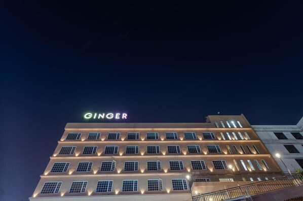 Un edificio a più piani con la scritta 'GINGER' illuminata in cima.