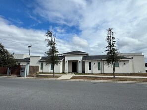 Ein modernes, zweistöckiges Haus mit Garage, Auffahrt und Blick auf die Straße.