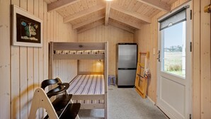 A small cabin with a bunk bed, a refrigerator, a dining table with chairs, and a window. - Gorgeous home in Otterup with WiFi (Otterup)
