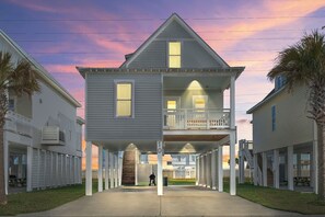 A two-story house with a balcony, a covered porch, and a number '10' sign. - Sunny Beachside Bungalow #10 Steps from the Sand in Galveston (Galveston)
