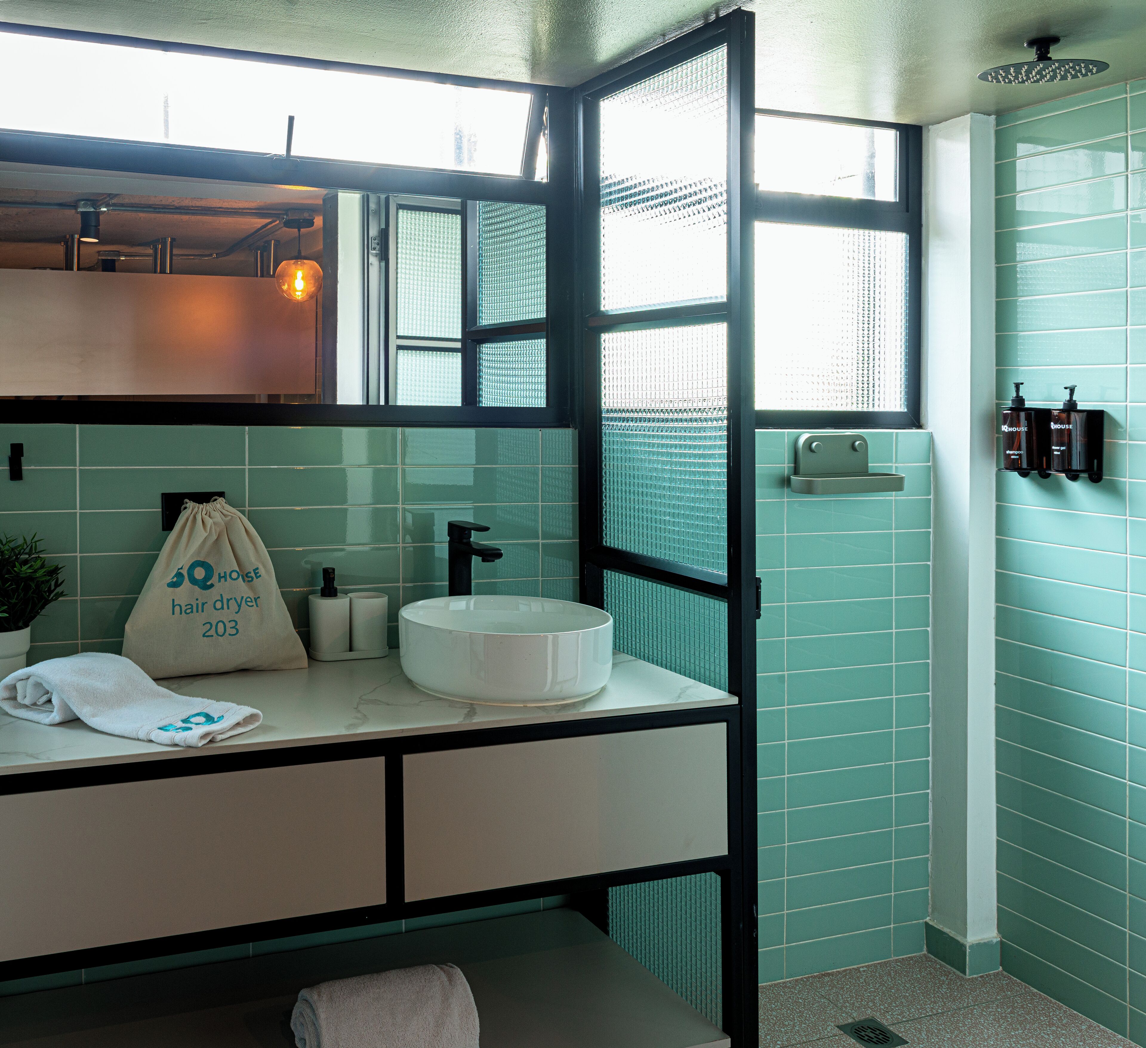 A bathroom with a white sink, a towel, a hair dryer, and a mirror.