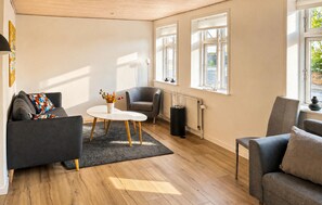 A modern living room with a sofa, armchair, round coffee table, and a radiator. - 3 bedroom gorgeous home in Faaborg (Faaborg)