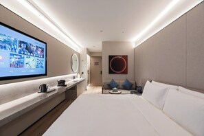 A modern hotel room with a large bed, a TV on the wall, a sofa, and a small table. - Orange Crystal Shanghai Lujiazui Expo (Shanghai)