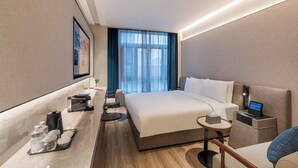 A hotel room with a bed, bedside table, chair, desk, and a window with curtains. - Orange Crystal Shanghai Lujiazui Expo (Shanghai)