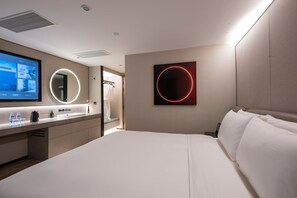 A modern hotel room with a large bed, a bathroom with a mirror, and a wall-mounted TV. - Orange Crystal Shanghai Lujiazui Expo (Shanghai)