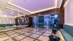 A modern lobby with a checkered floor, seating areas, and a glass entrance. - Orange Crystal Shanghai Lujiazui Expo (Shanghai)