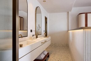 A modern bathroom with a large mirror, two sinks, and a bench. - Nammos Hotel Mykonos & Villas (Mykonos)