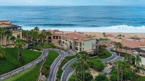 Un complejo turístico frente al mar, con varias edificaciones, una playa y vistas al océano.