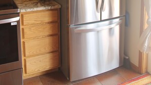 A kitchen with wooden cabinets, a stainless steel refrigerator, a toaster, and a microwave. - 2 bedroom 2 bath cozy cabin on 40 acres in Fairplay. (Fairplay)