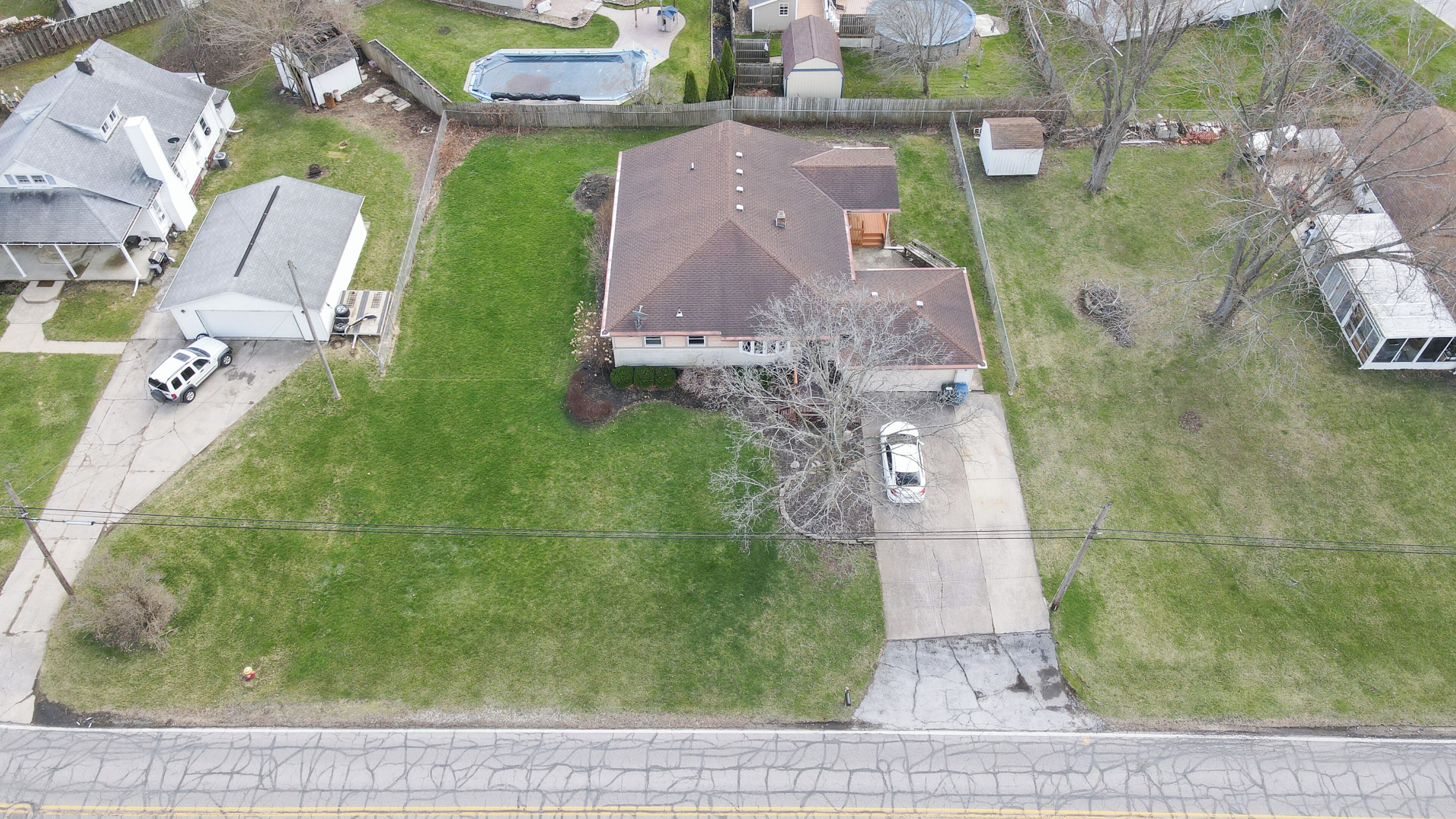 A residential house with a sloped roof, a front yard, and a driveway.