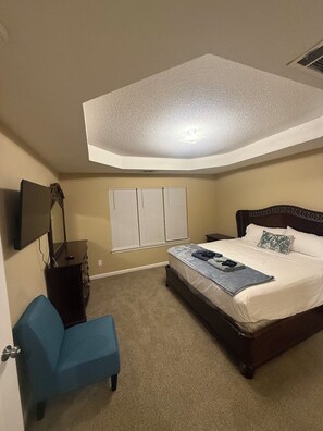 A bedroom with a bed, a desk, a chair, and a TV mounted on the wall. - 4-bedroom house in Fairburn close to the airport. Perfect for World Cup visits. (Fairburn)