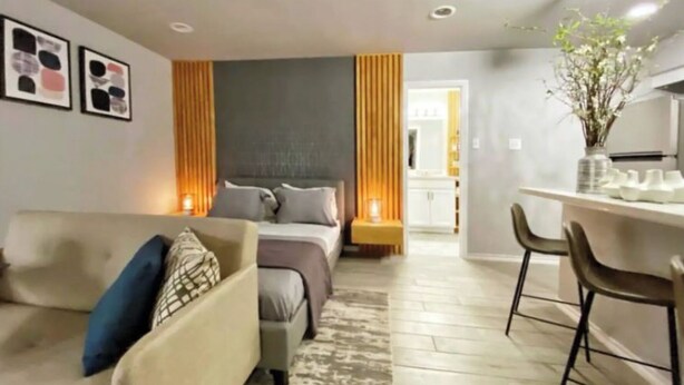 Et moderne hotelværelse med seng, sofa, skrivebord og spiseplads.
