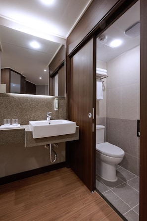 A modern bathroom with a sink, mirror, and toilet. - The Hotel Sokcho (Sokcho)