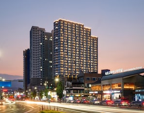 A high-rise building with multiple floors, a bus terminal, and various commercial establishments. - The Hotel Sokcho (Sokcho)