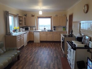 Una cocina compacta con armarios de madera, lavavajillas, estufa y ventana con vistas.