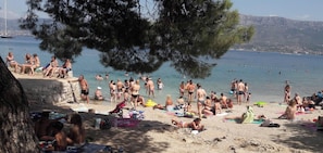 A beach with people sunbathing and swimming. - Comfortable apartment in the center of Split (Split)
