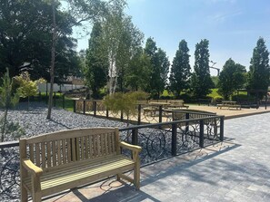 A park with benches, a paved walkway, and trees. - Modern Apartment - Sleeps 4 - Centrally located (Lanark)
