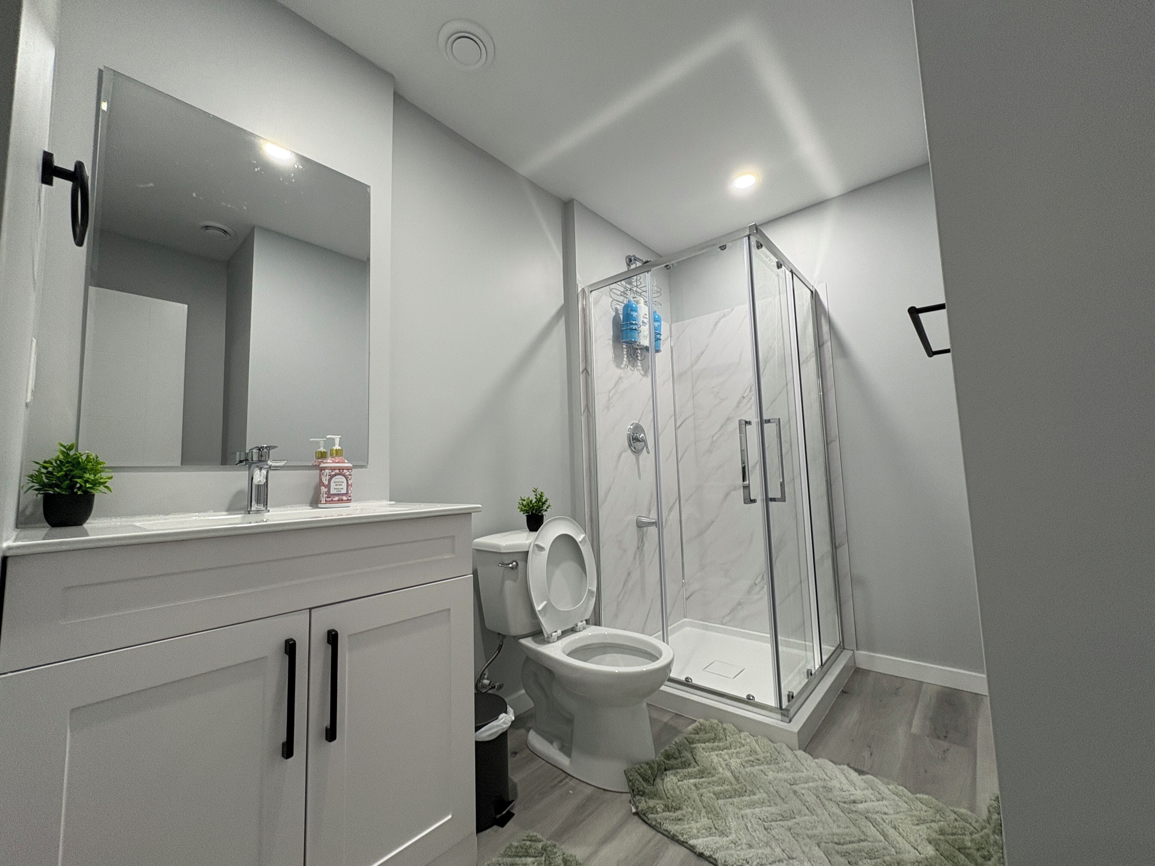 Un baño moderno con inodoro, lavamanos y ducha.