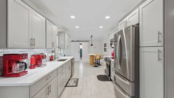 Full-size fridge, stovetop, cookware/dishes/utensils