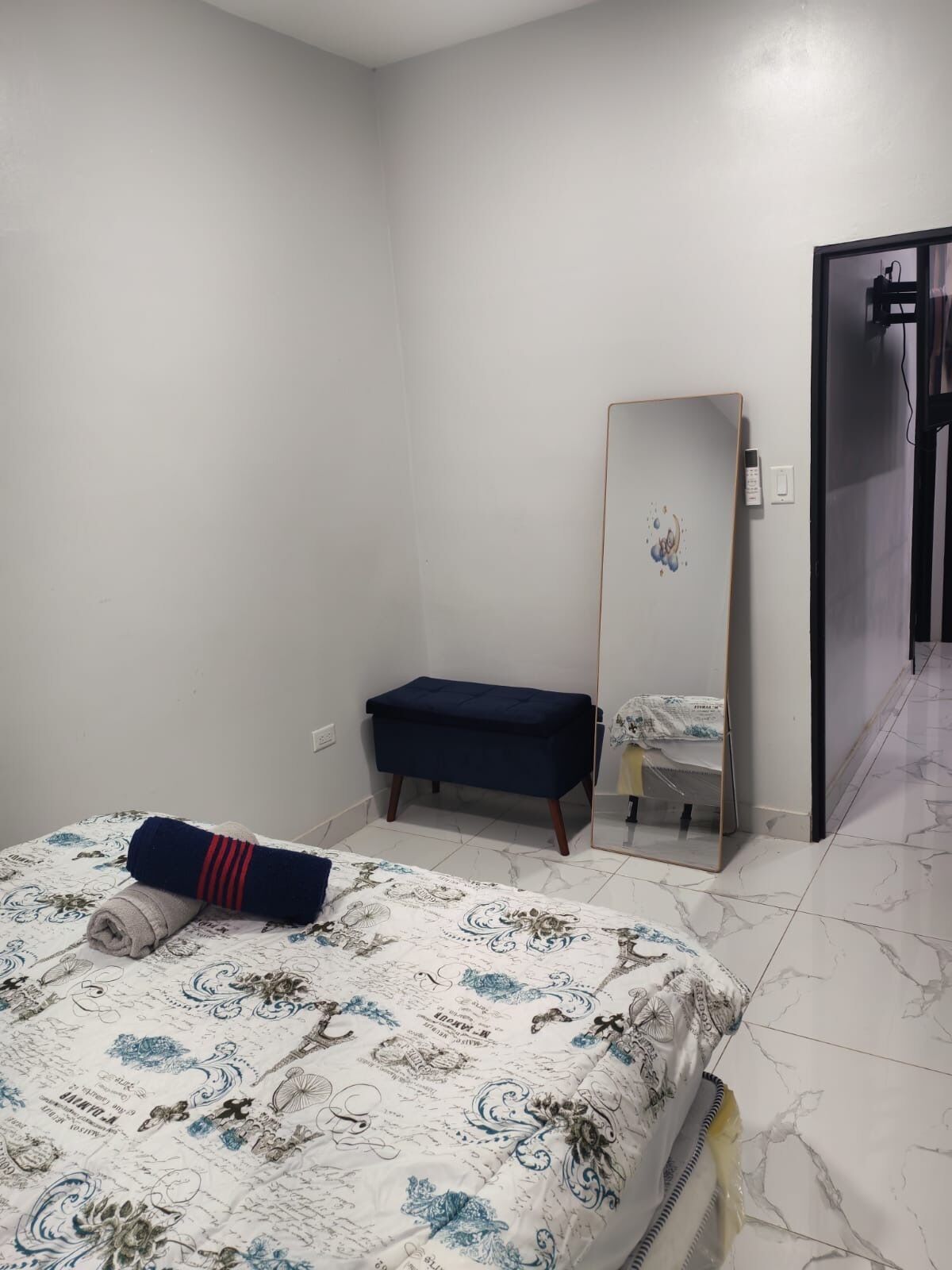 Un dormitorio con cama, mesita de noche, espejo y armario.