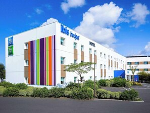 Edifício de hotel moderno com fachada branca e listras verticais em várias cores.
