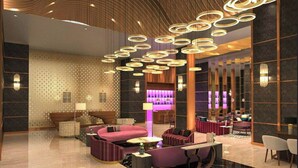 Eine moderne Lobby mit gewölbter Decke, runden Leuchten und einer Bar.