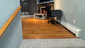 A living room with a fireplace, a TV mounted on the wall, and a piano. - Central Fairbanks 3BR/2BA,  King Bed,  Sleeps 6, Free Laundry (Fairbanks)