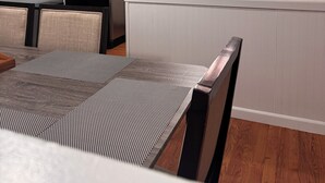 A modern kitchen with white cabinets, a black refrigerator, and a dining area with a table and chairs. - Central Fairbanks 3BR/2BA,  King Bed,  Sleeps 6, Free Laundry (Fairbanks)