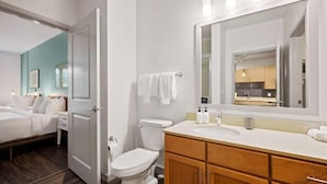 Un baño moderno con inodoro, lavabo y espejo.