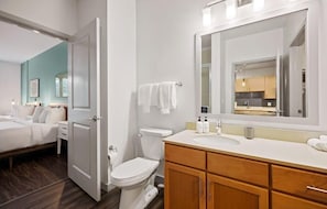 Ein modernes Badezimmer mit Toilette, Waschbecken und Spiegel.
