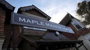 A hotel sign with the name 'Maple Manor Hotel' and a partially visible address. - The Maple Manor Hotel (Crawley)