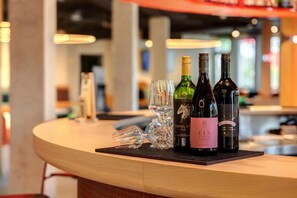 A bar area with a wooden counter, wine bottles, and glasses. - Dein Apart (Unterfoehring)