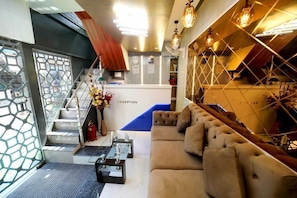 A reception area with a sofa, a staircase, and a wall with hanging lights. - N.m. Hotel Mumbai (Mumbai)