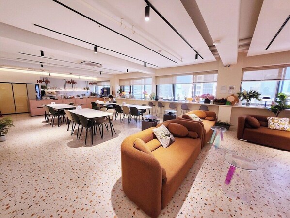 Un interior moderno con zona de comedor, cocina y espacio para sentarse.