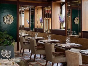 A restaurant with booths, round tables, and a checkered floor. - Orient Express Palazzo Dona Giovannelli (Venice)